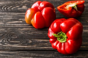 Red bell pepper on wooden background.