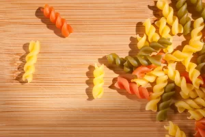 Shot of colorful italian pasta drenched in natgural sunlight on cutting board.